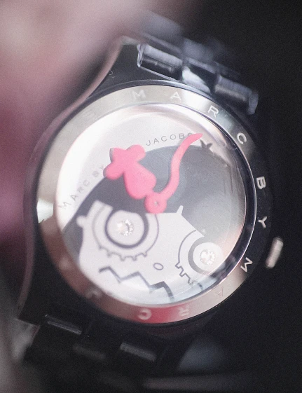 a wrist watch with a red bear on the front of it