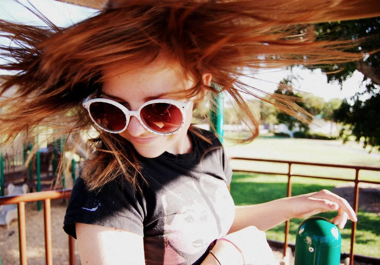 girl in sunglasses posing with her hair flying in the wind