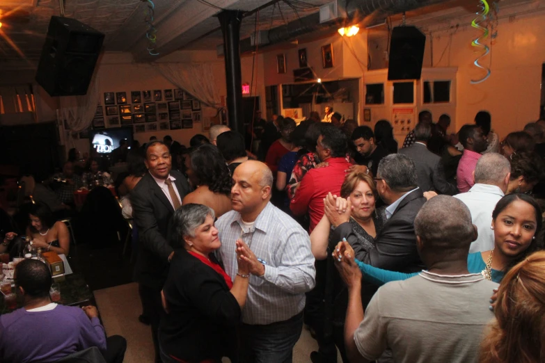 a crowd of people dance at a function