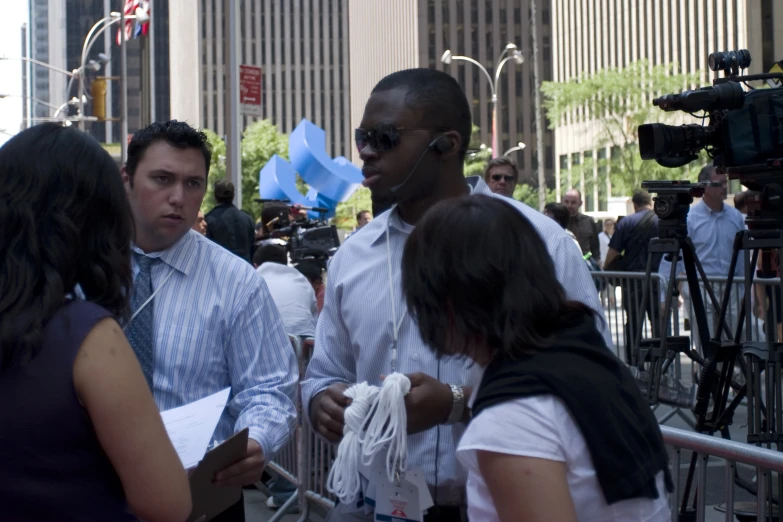 a man wearing sunglasses and a headphone in a crowd of people