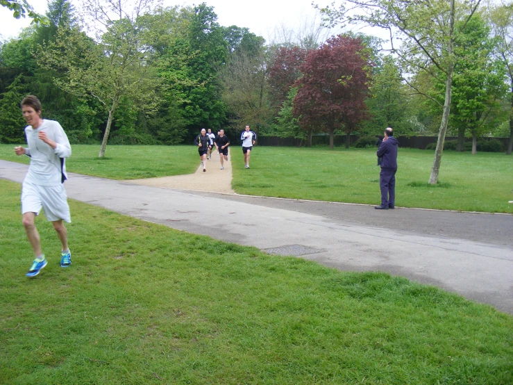 a group of people running in the park on a rainy day