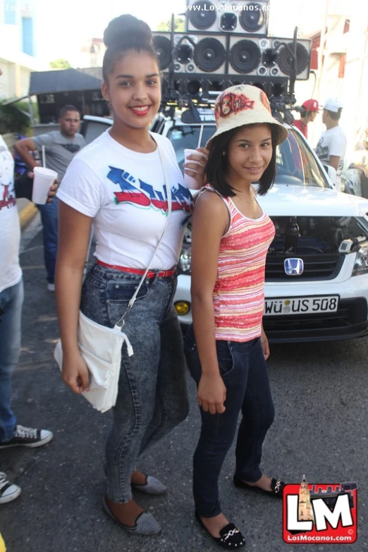 two teenage girls in front of some cars