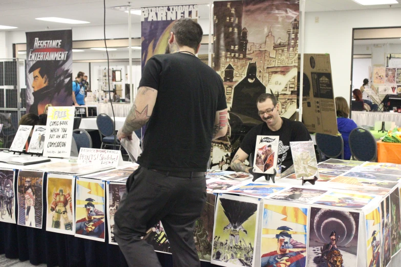 two men standing at the table with comic books