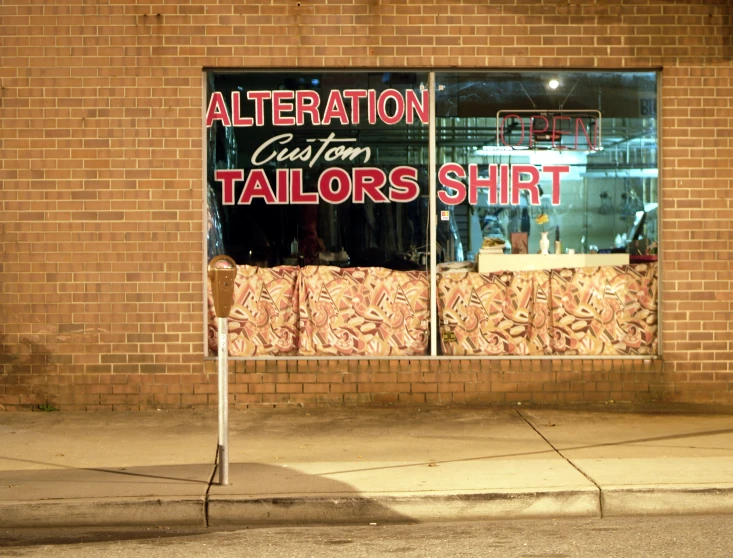 a storefront displaying a tailors shirt window