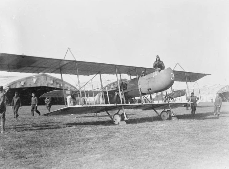 an old time airplane that is on some grass