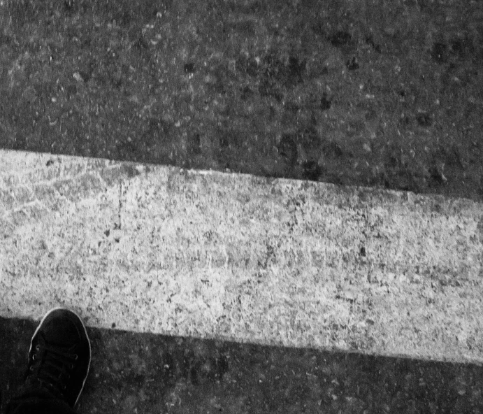 two people walking across an asphalt street