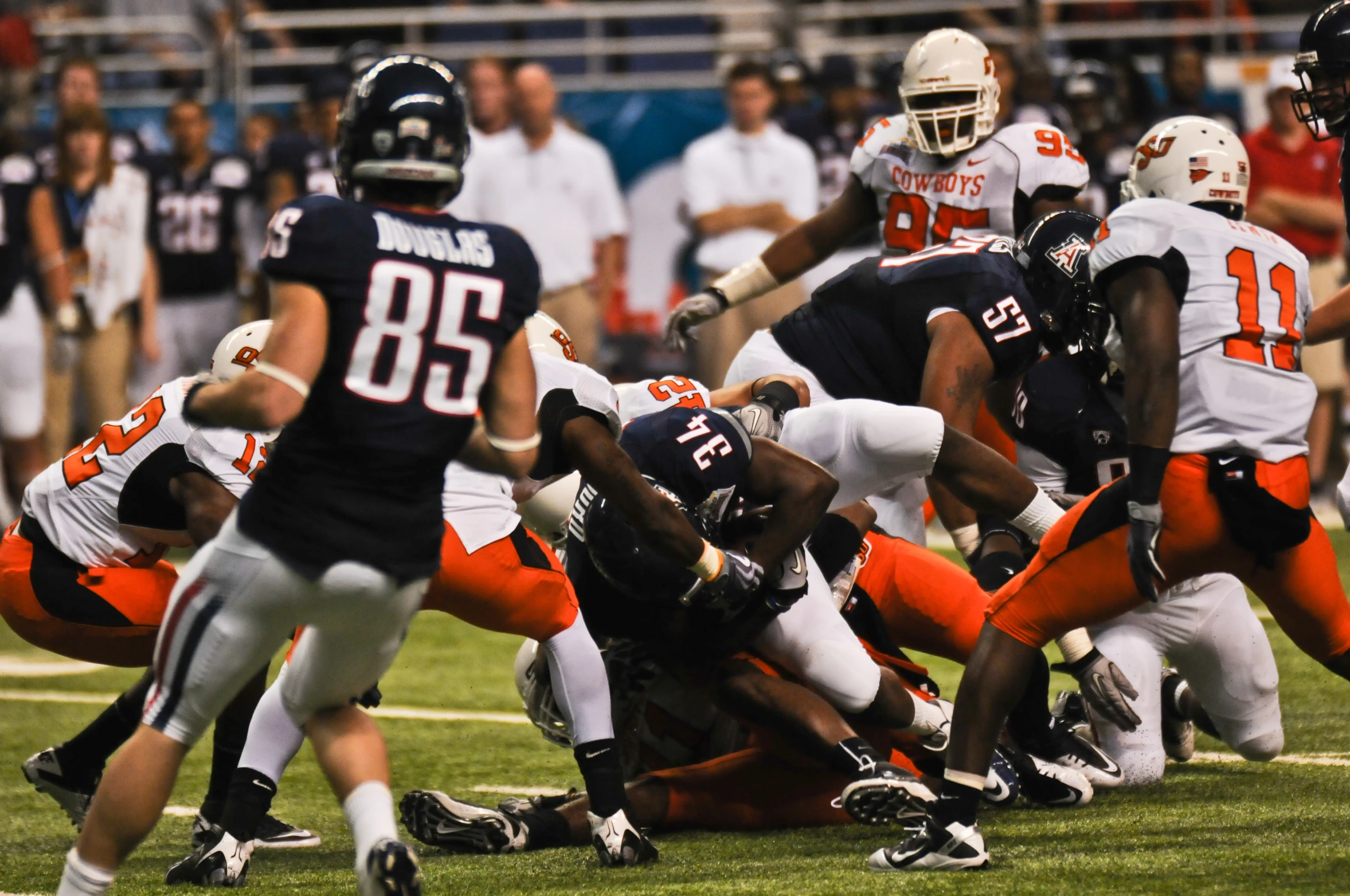 football players are playing in an orange and black game