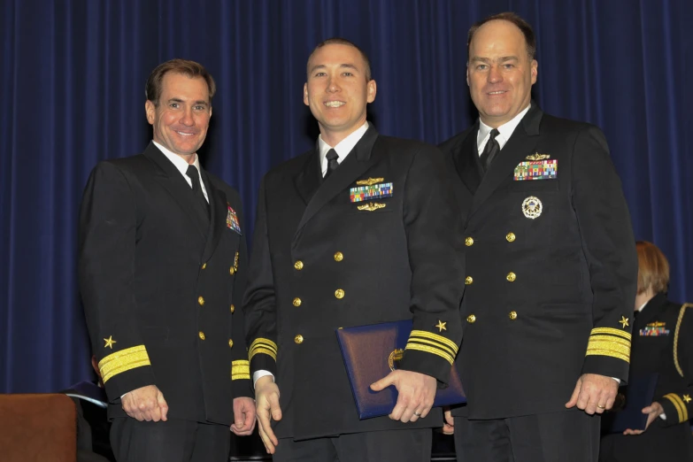 three men in military uniforms standing side by side