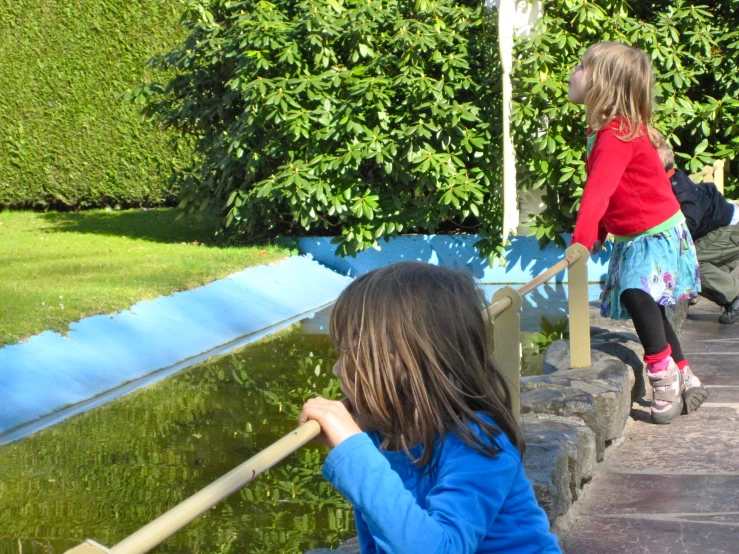 two young children looking at soing in the water