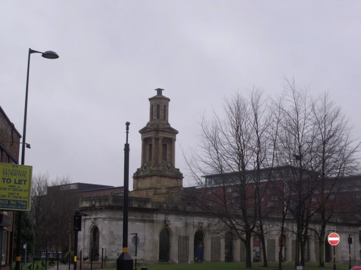 a building with a clock tower sitting behind some trees