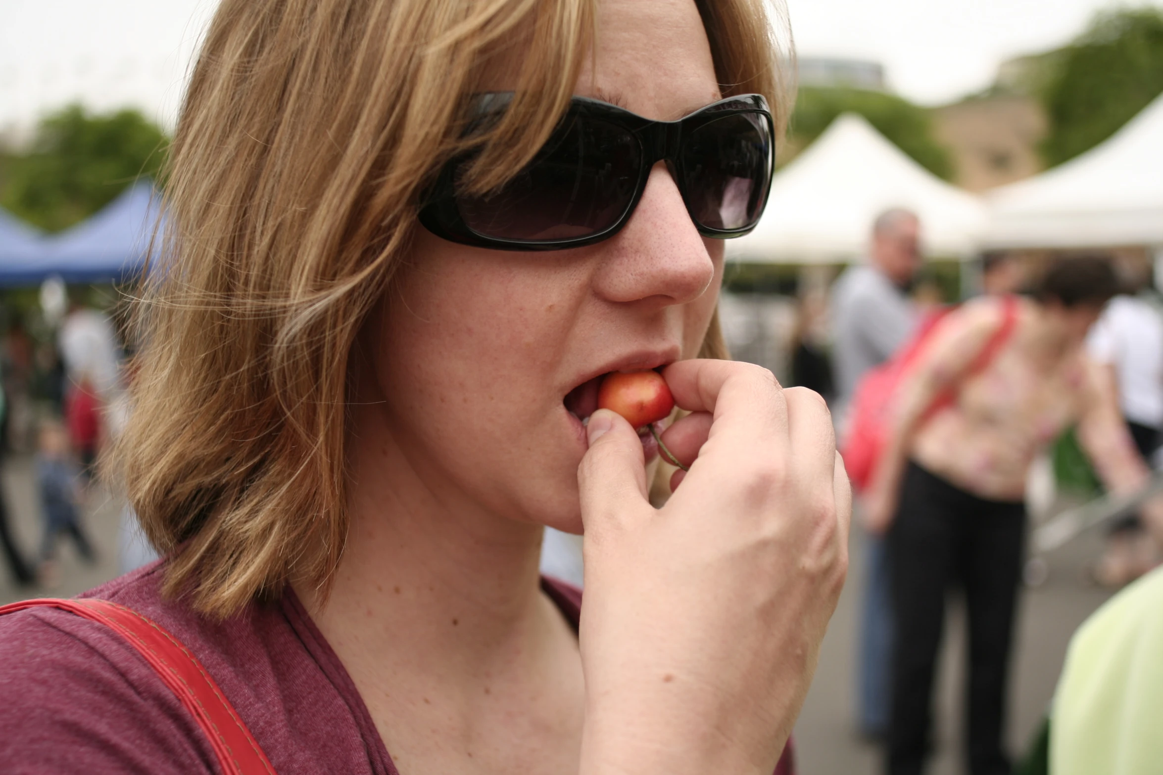 the lady is eating a slice of fruit