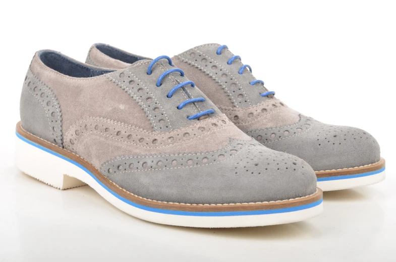 grey derby shoes with blue laces on a white surface