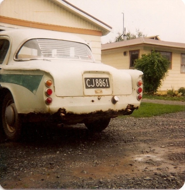 an old car is parked outside in front of a house