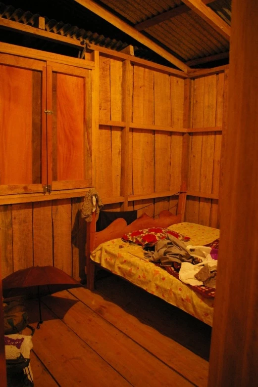 a bed sitting inside of a wooden room