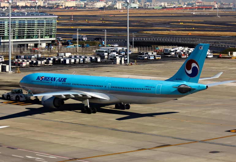 a blue commercial jet on the ground in a parking lot