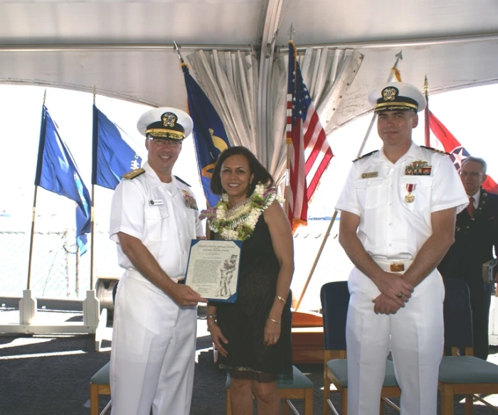 two men and a woman who are standing in front of flags