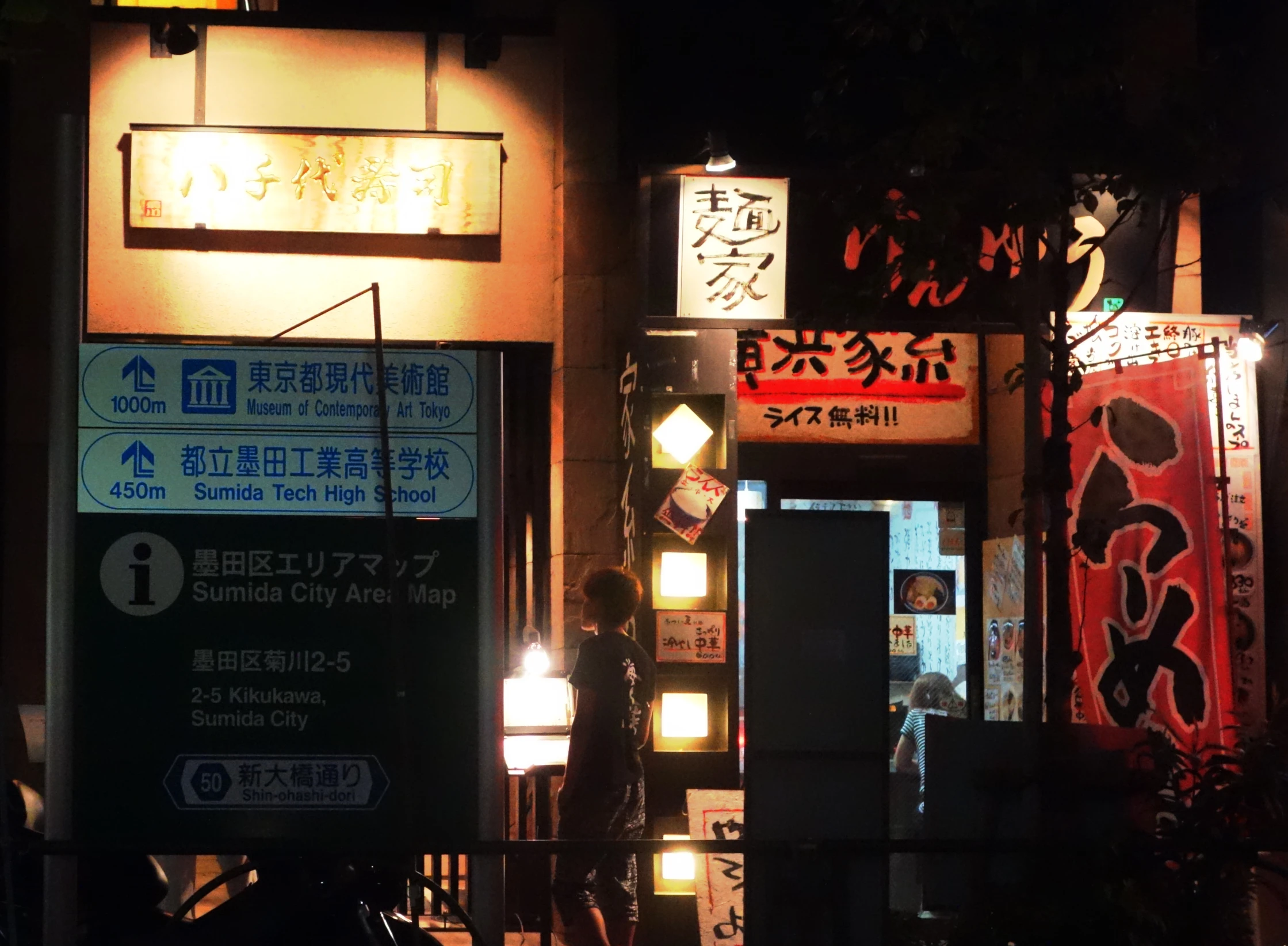 a group of asian signs on an urban street at night