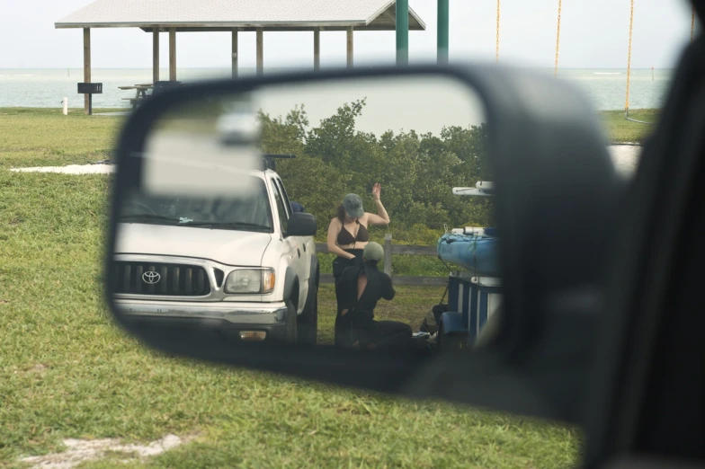 a person taking a picture from a car mirror