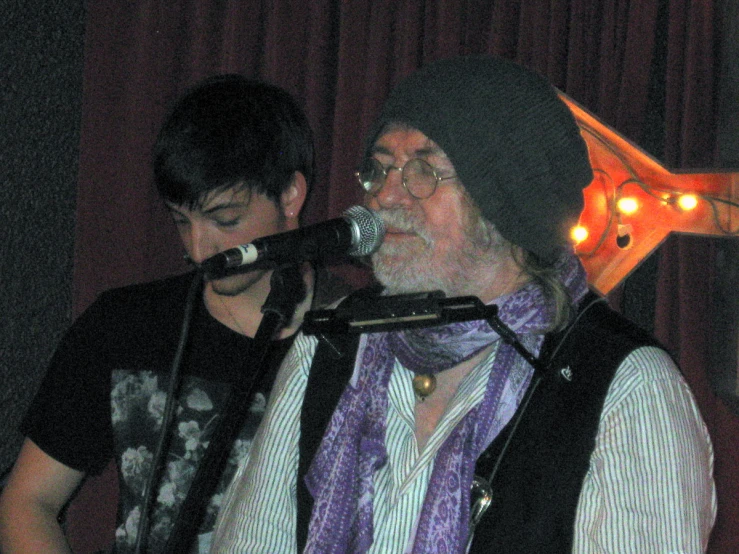 two men are singing into a microphone