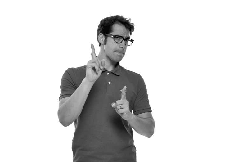 a man in glasses points to his left and is holding his fingers