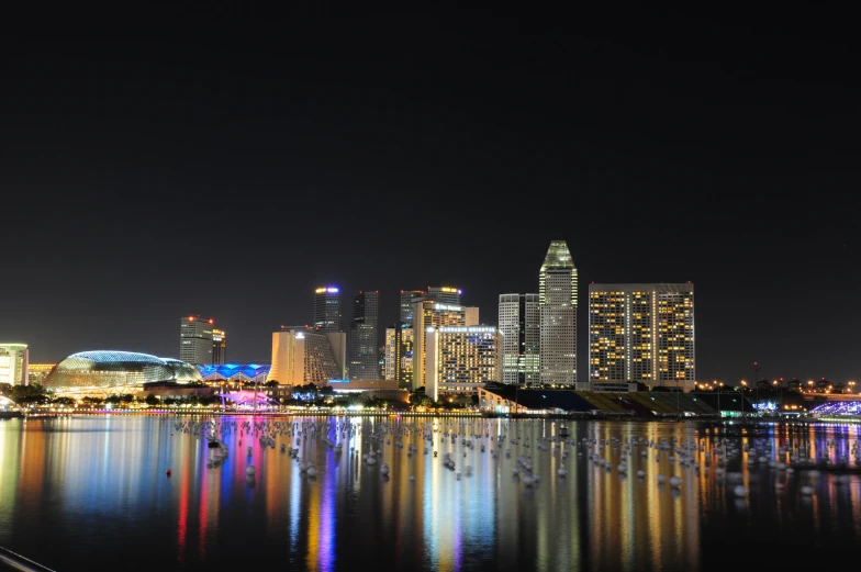 a city view at night is very bright and reflected in the water