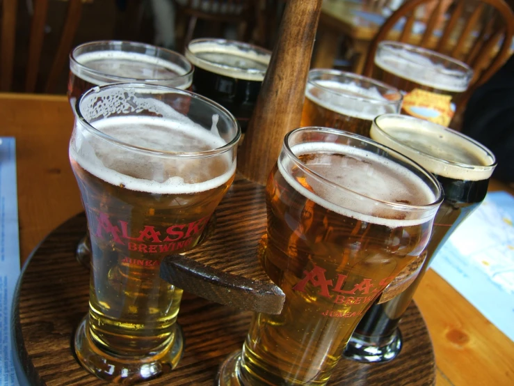 beer glasses on a wooden coaster on a table