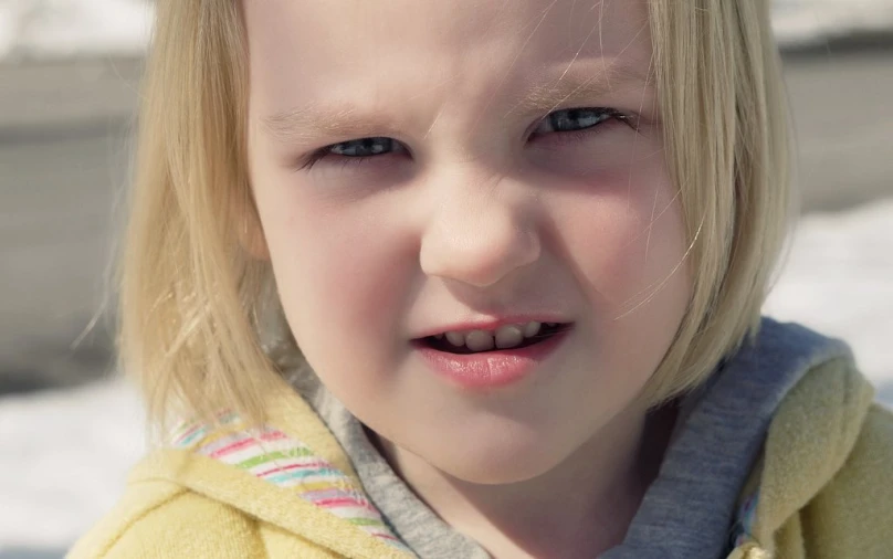 a little girl is looking off into the distance and smiling