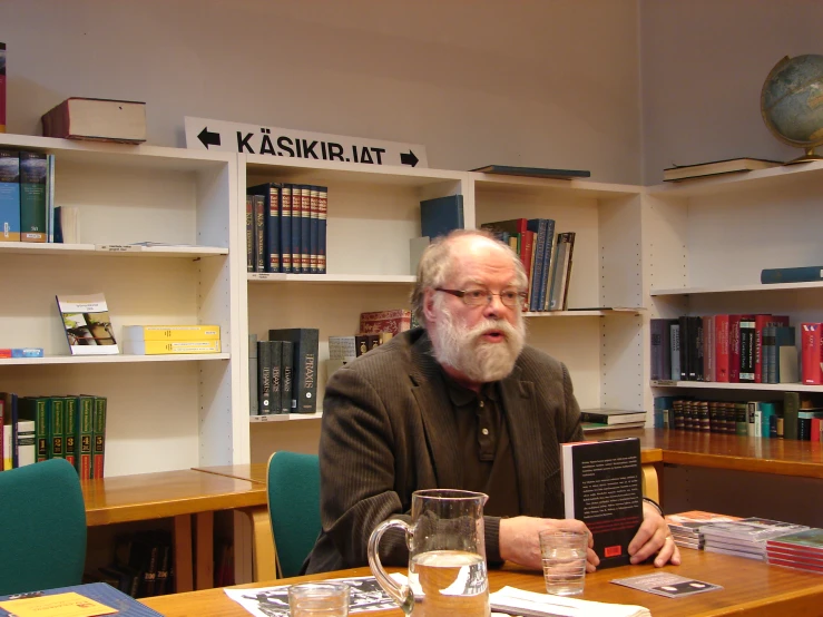 a man sits at a desk with a book