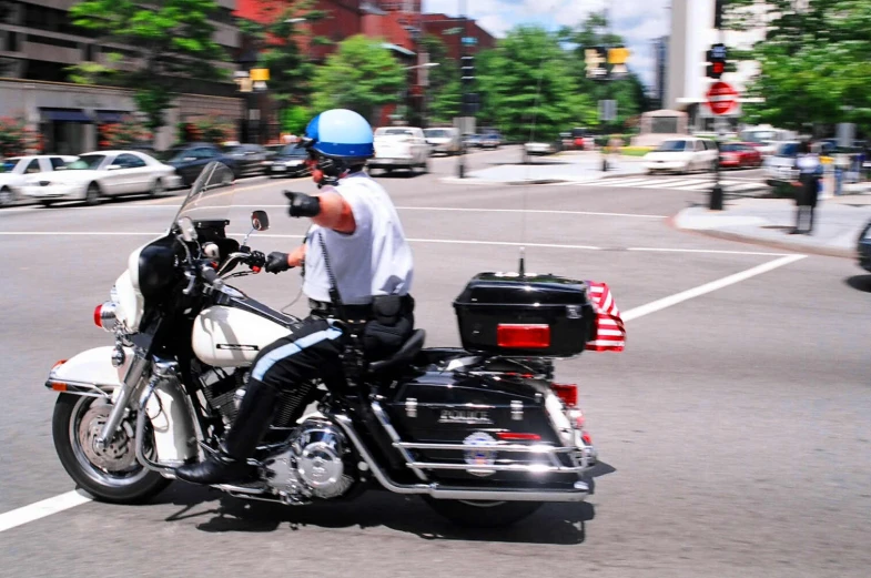 the cop is driving down the street on his motorcycle