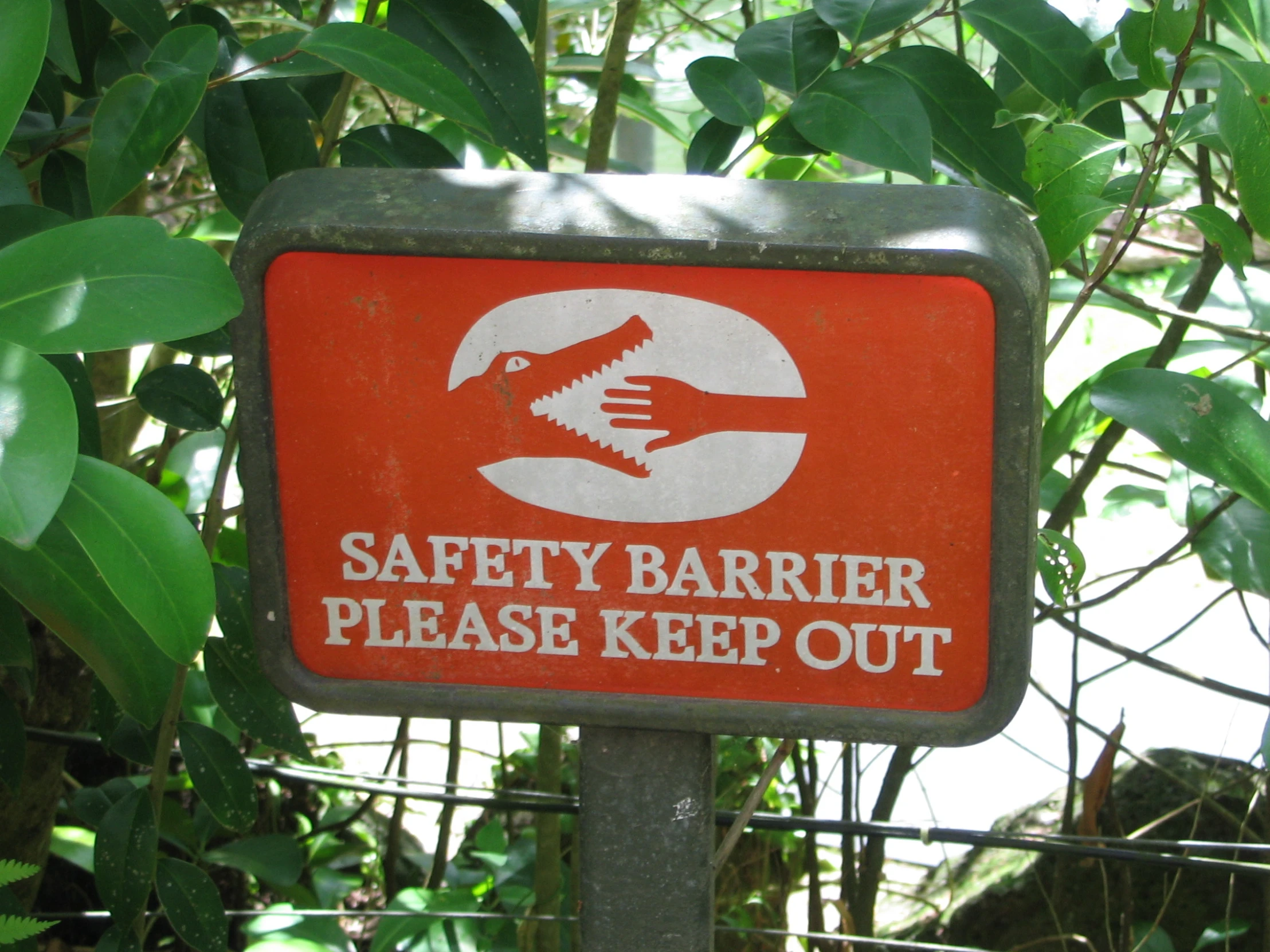 a red and white sign sitting on top of a forest