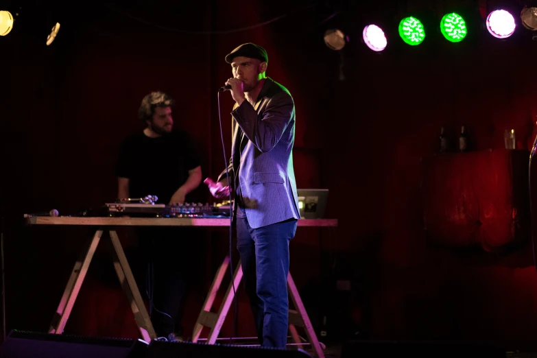 two men standing in front of a microphone at a music event