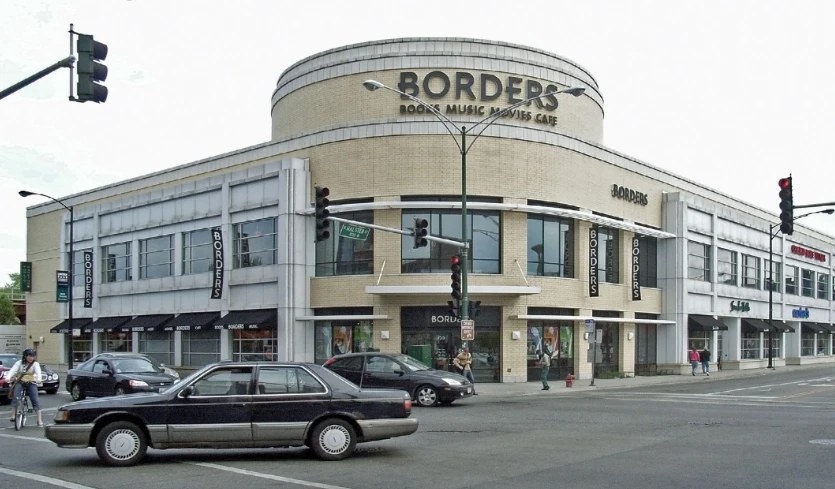 some cars driving down the street in front of a store