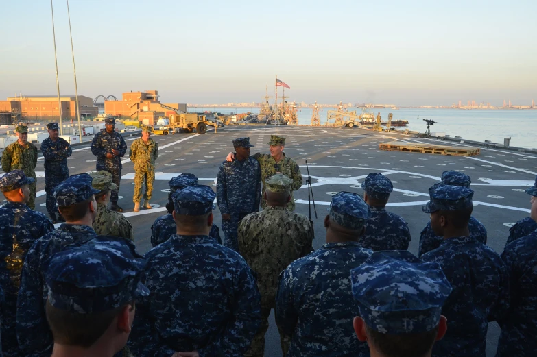 a group of men are standing on the deck of a ship