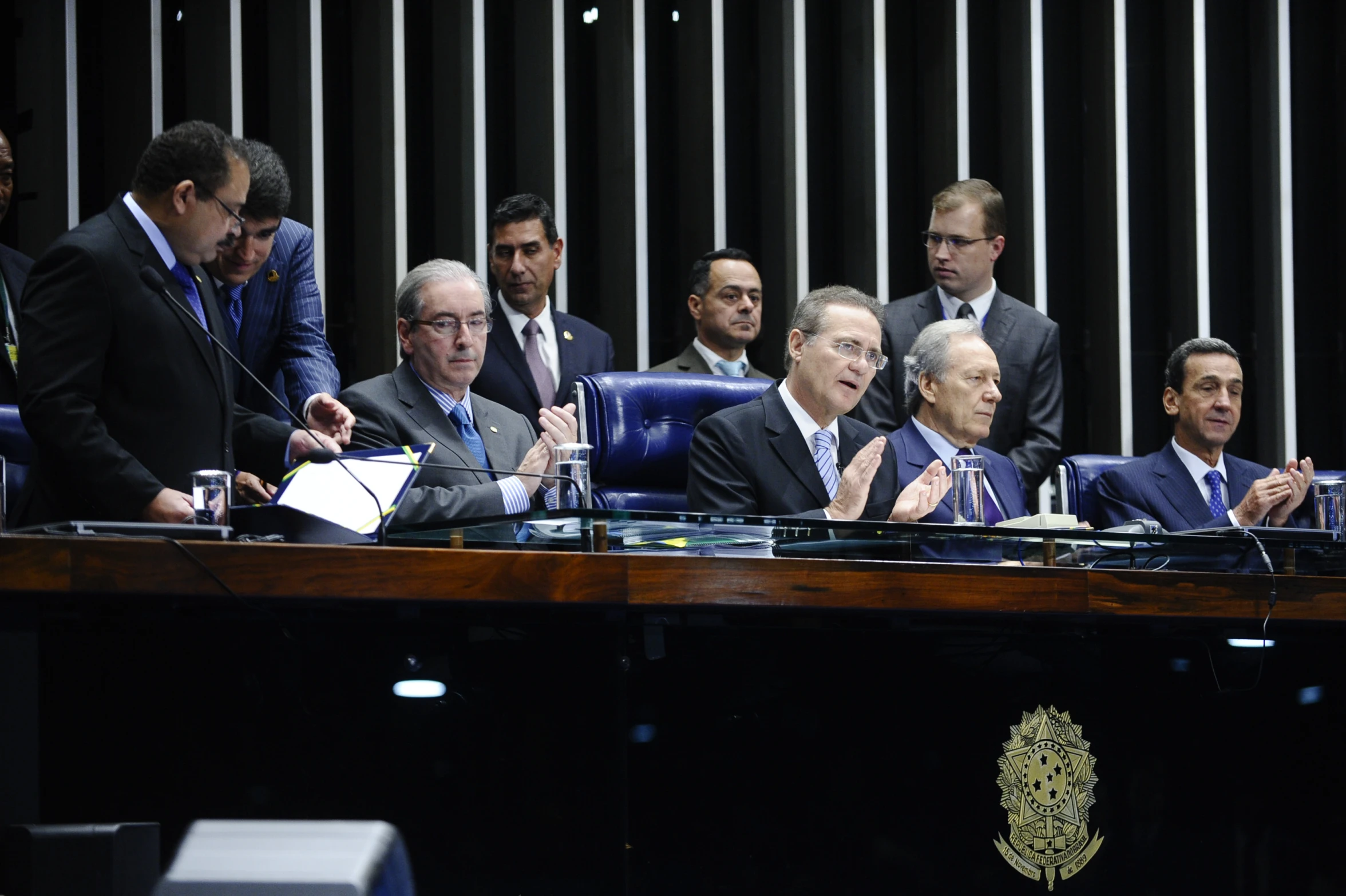 people sit at a desk in front of the speaker