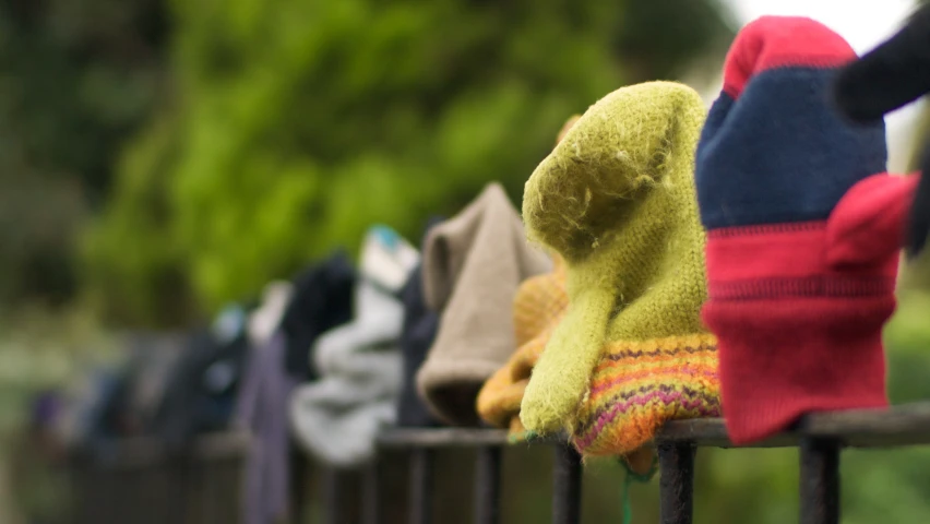 a row of knitted teddy bears behind an iron fence