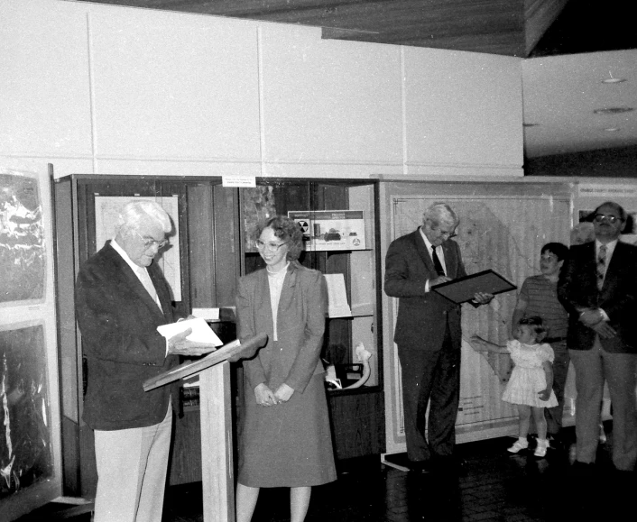 a man and woman are exchanging documents at a ceremony