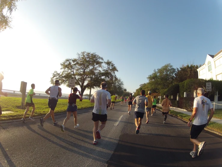 several people are running in a single file on a paved street