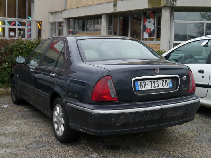 a black sedan parked in front of a building