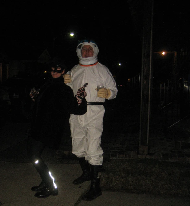 two people standing on the side walk near a street