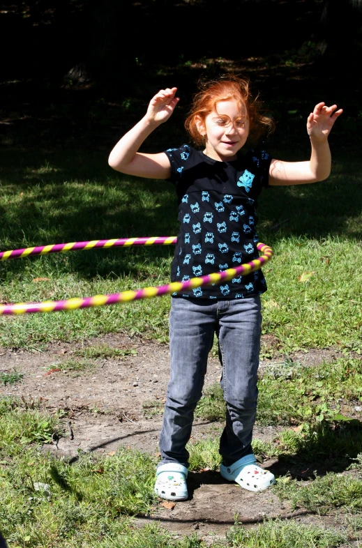 girl with red hair wearing a black shirt and holding up a small plastic tube