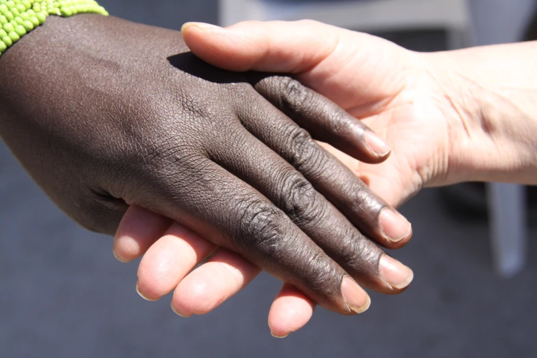 a close up of two people holding hands