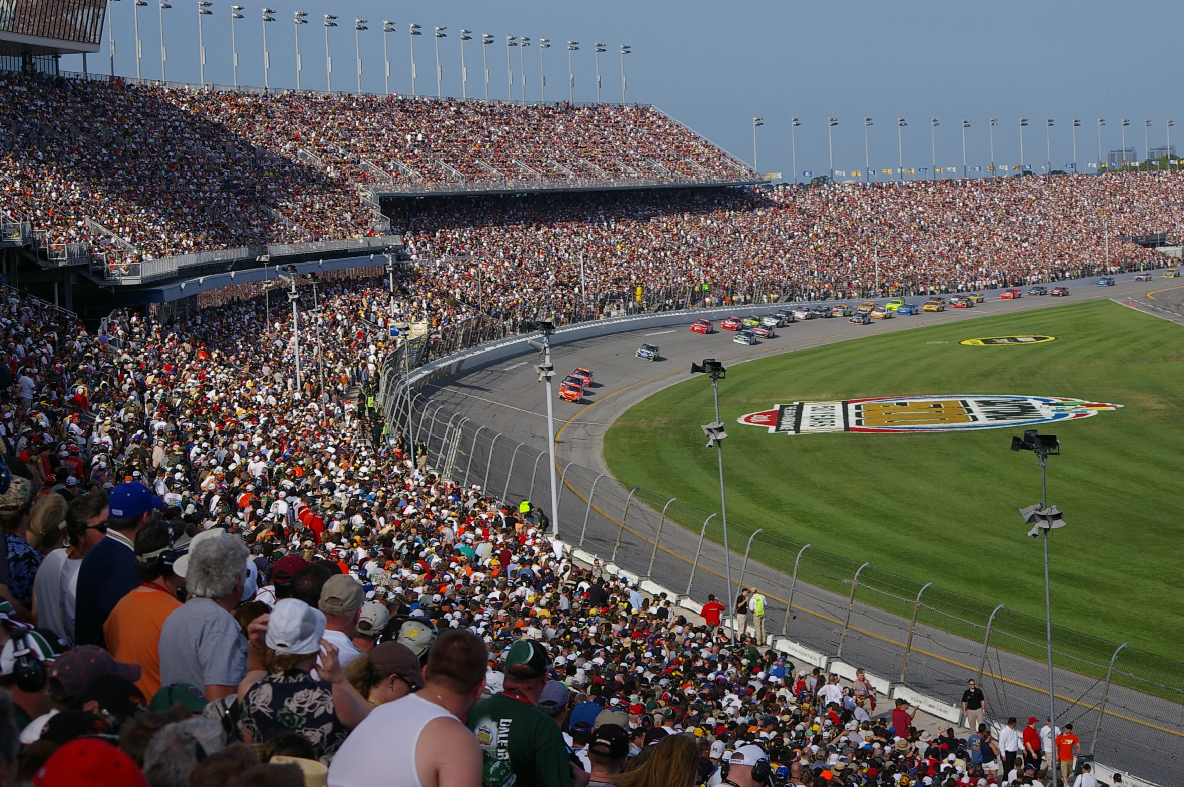 a large crowd is watching two motorcycle racers on a track