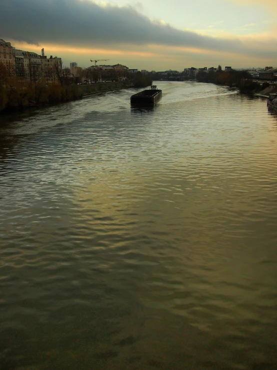 a river is flowing under a gray cloudy sky