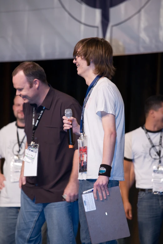 two people with their hands on each of their backs are standing on stage