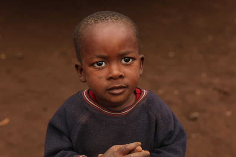 a black boy posing for a picture while holding his hand out