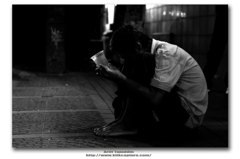 a person that is sitting on the ground reading soing