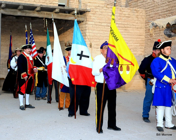 people in uniforms holding flags in a courtyard