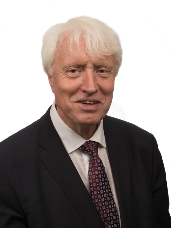 an older man wearing a black suit and red tie