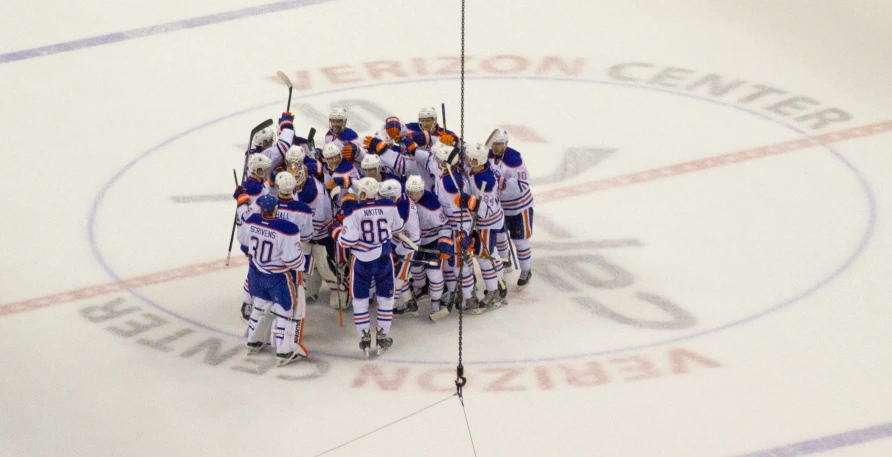 a hockey team huddled up on the ice