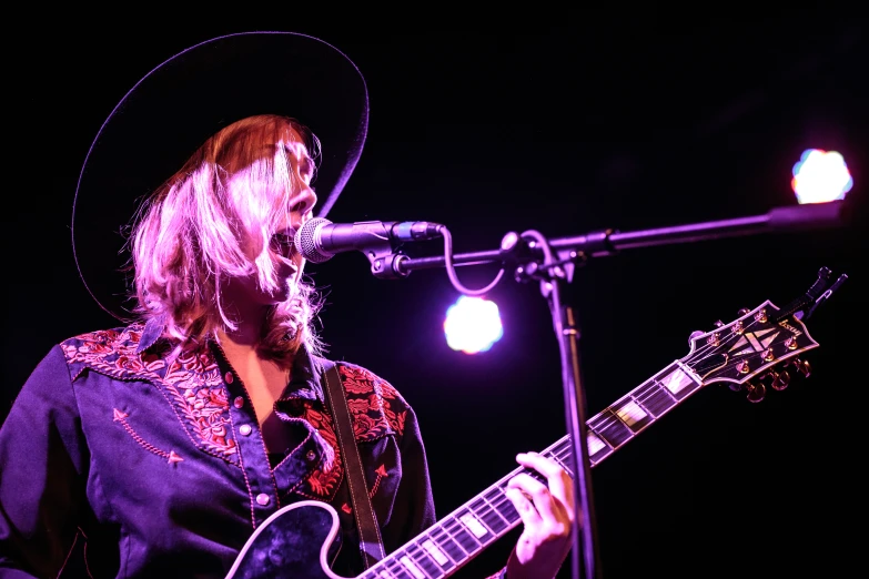 a person that is playing the guitar on stage